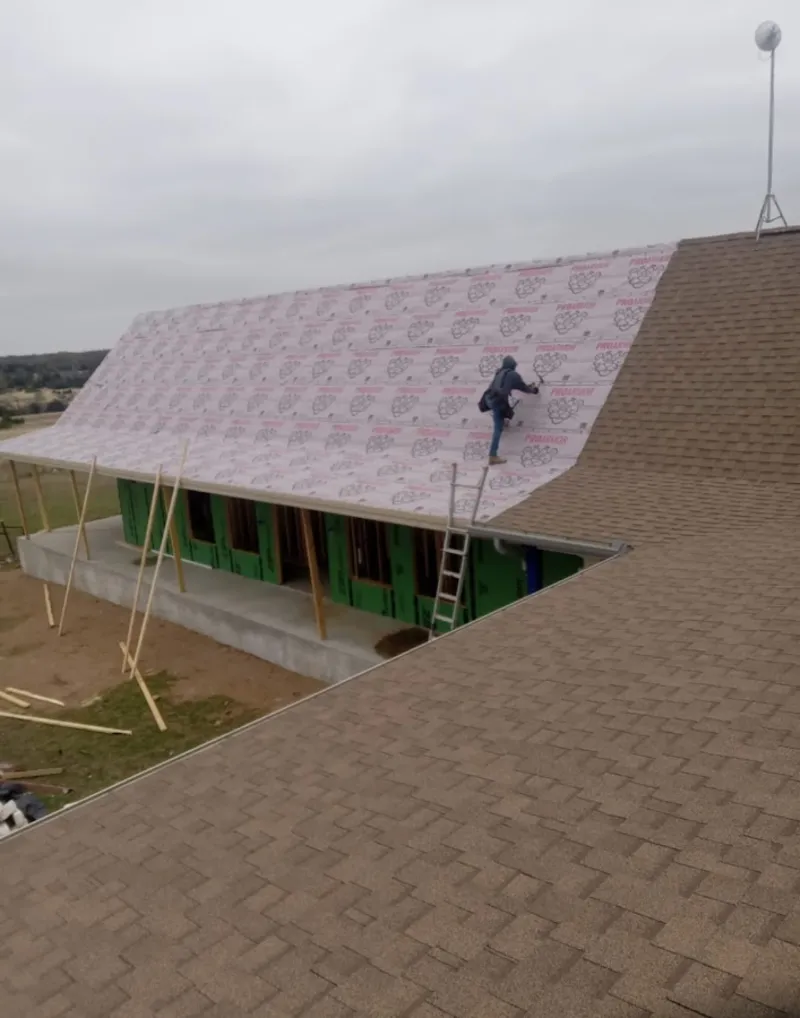 Worker preparing underlayment for a metal roof installation in Lucerne Valley